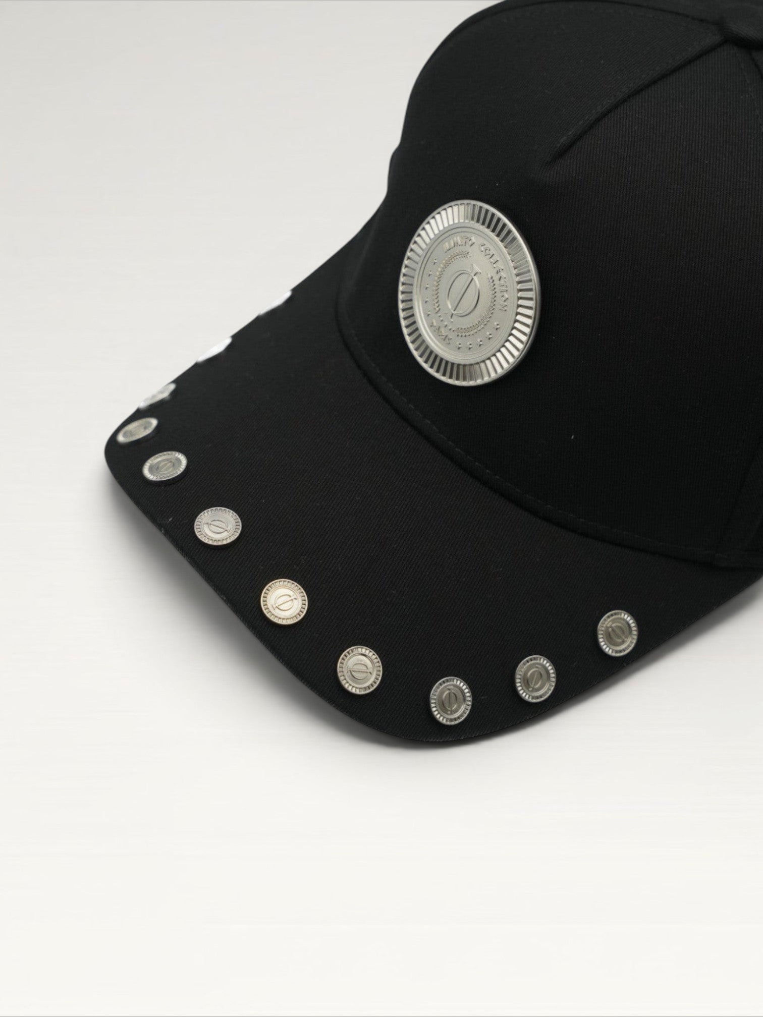 ILIMITO black cotton blend cap with curved brim, silver medallion detail on front, and silver medal accents on visor.