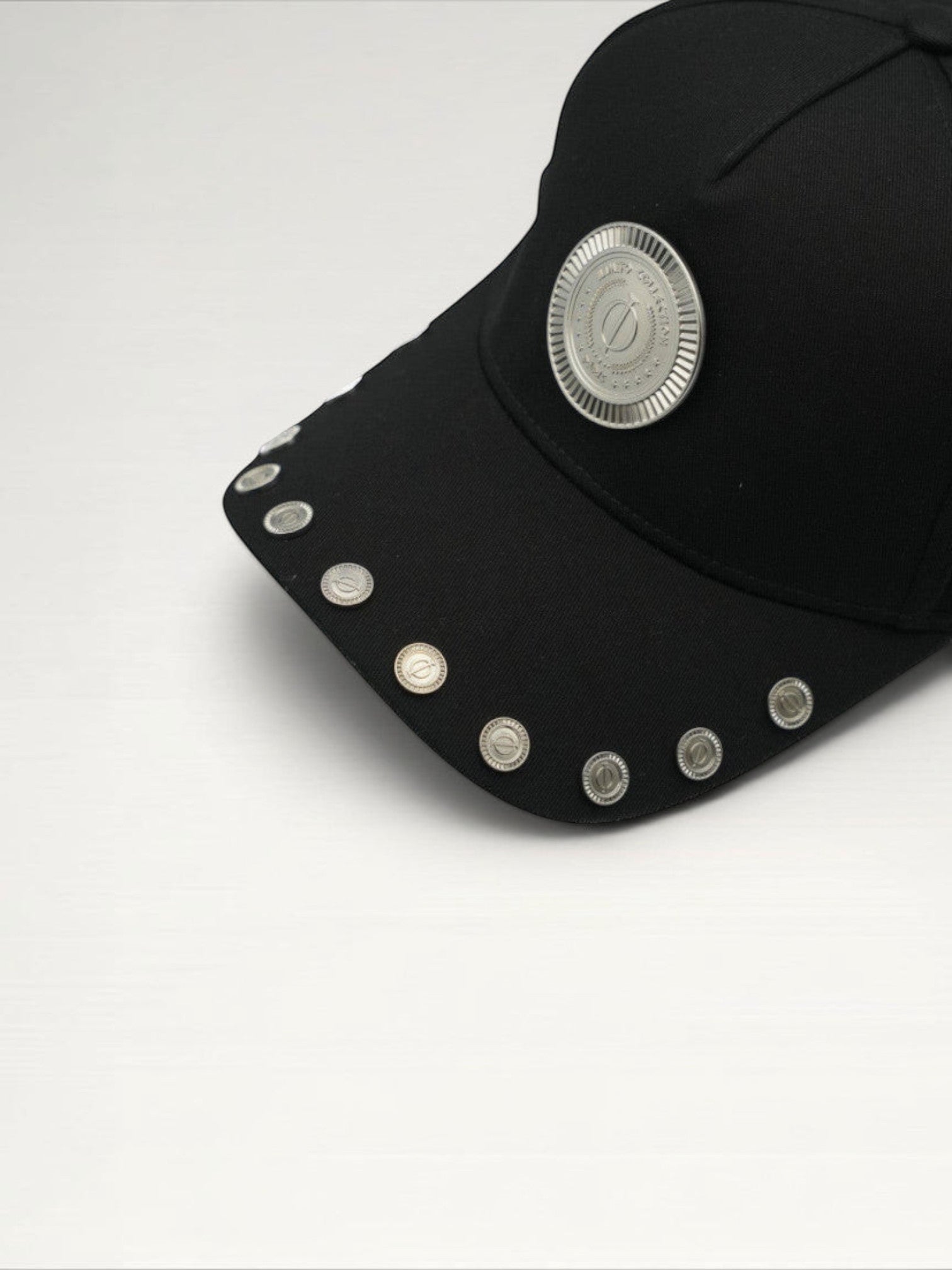 ILIMITO black cotton blend cap with curved brim, silver medallion detail on front, and silver medal accents on visor.