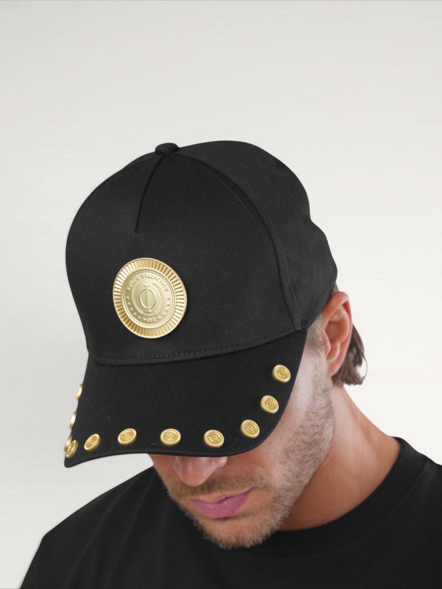 ILIMITO black cotton blend baseball cap with gold medallion emblem and gold medal accents on the visor.