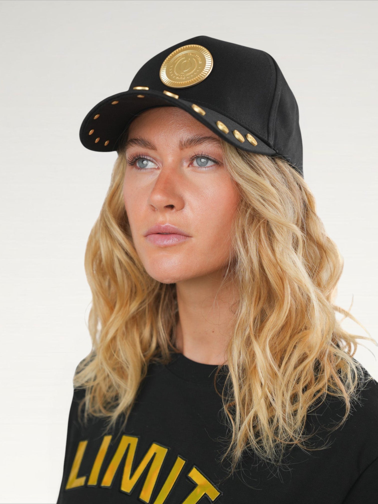 ILIMITO black cotton blend baseball cap with gold medallion emblem and gold medal accents on the visor.
