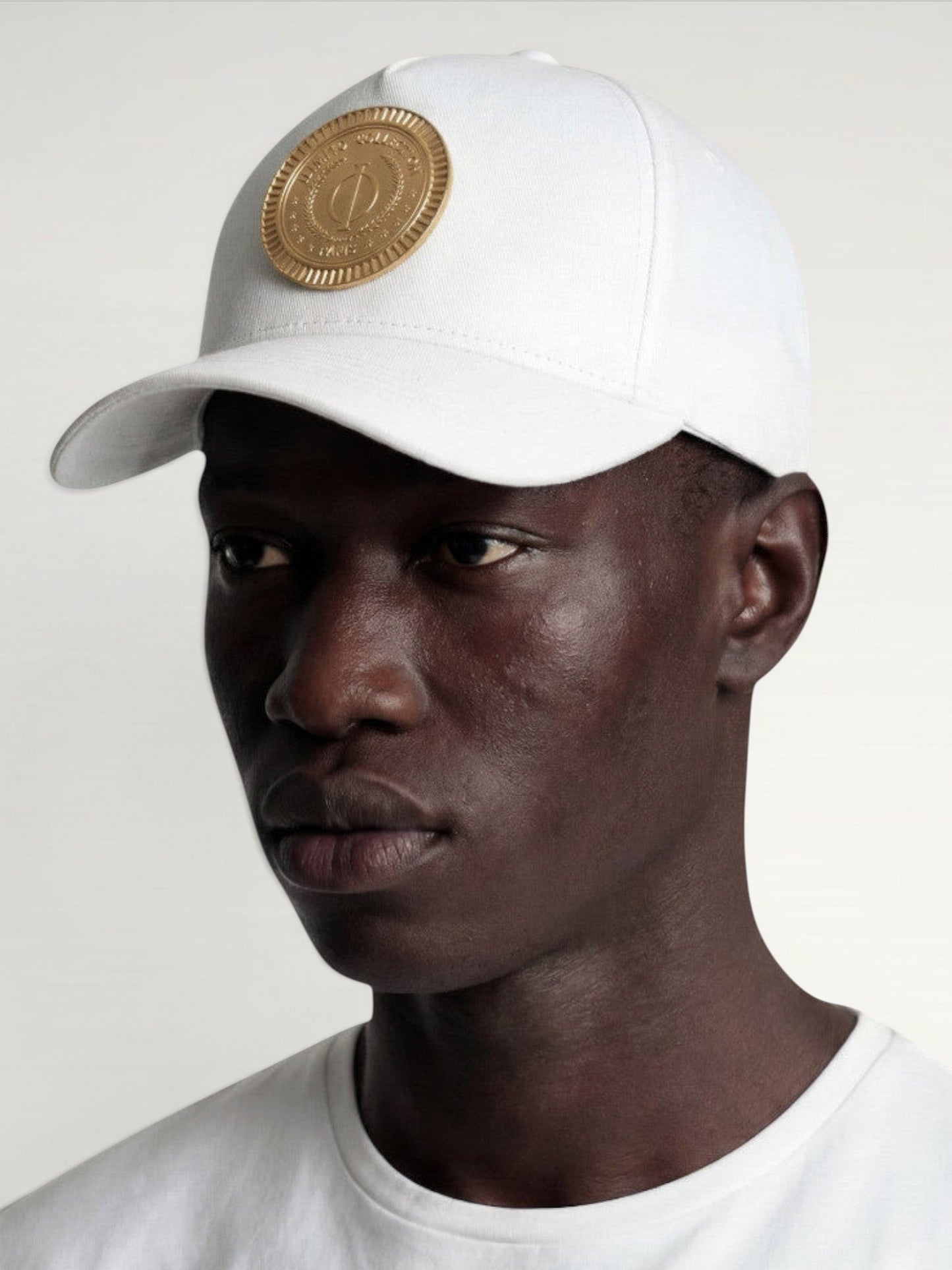 ILIMITO white cotton blend cap with gold medallion detail and accents on the visor. Unisex, adjustable fit