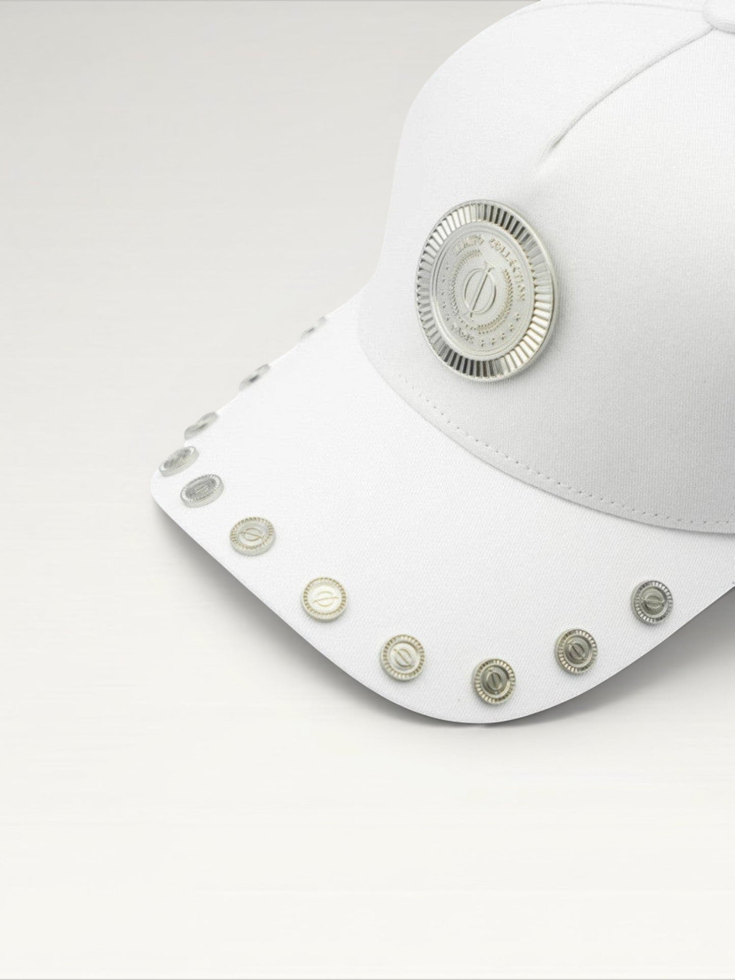 ILIMITO white cotton blend cap with silver medallion detail and accents on the visor. Unisex, adjustable fit.