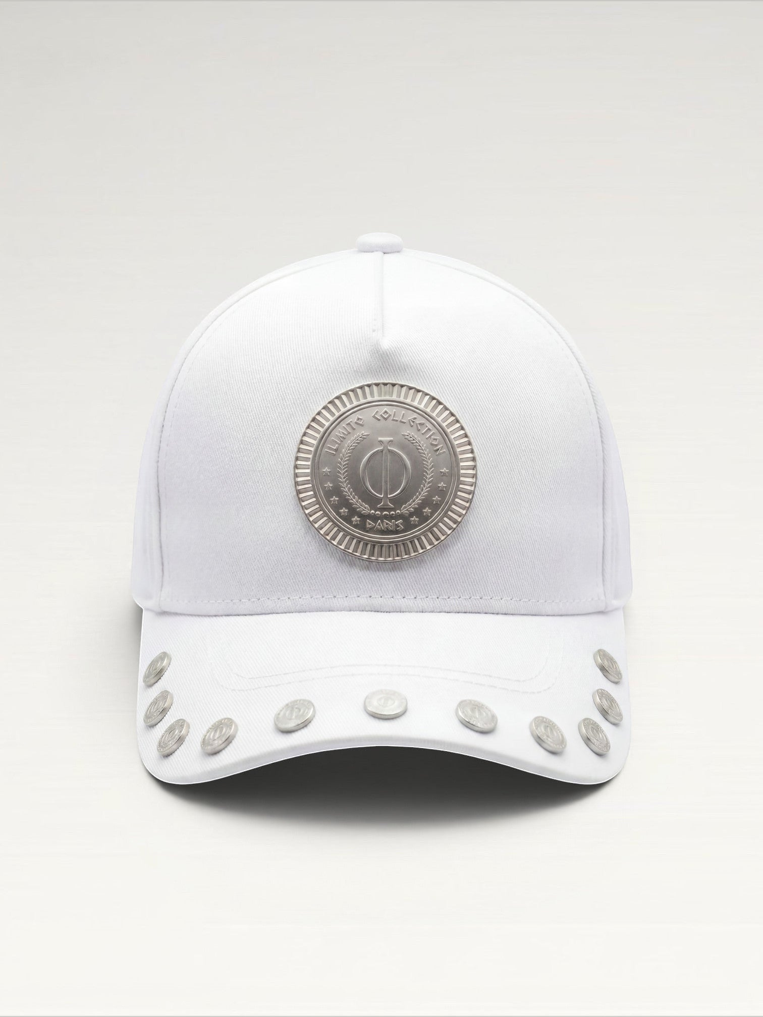 ILIMITO white cotton blend cap with silver medallion detail on the crown and silver medal accents on the curved brim.