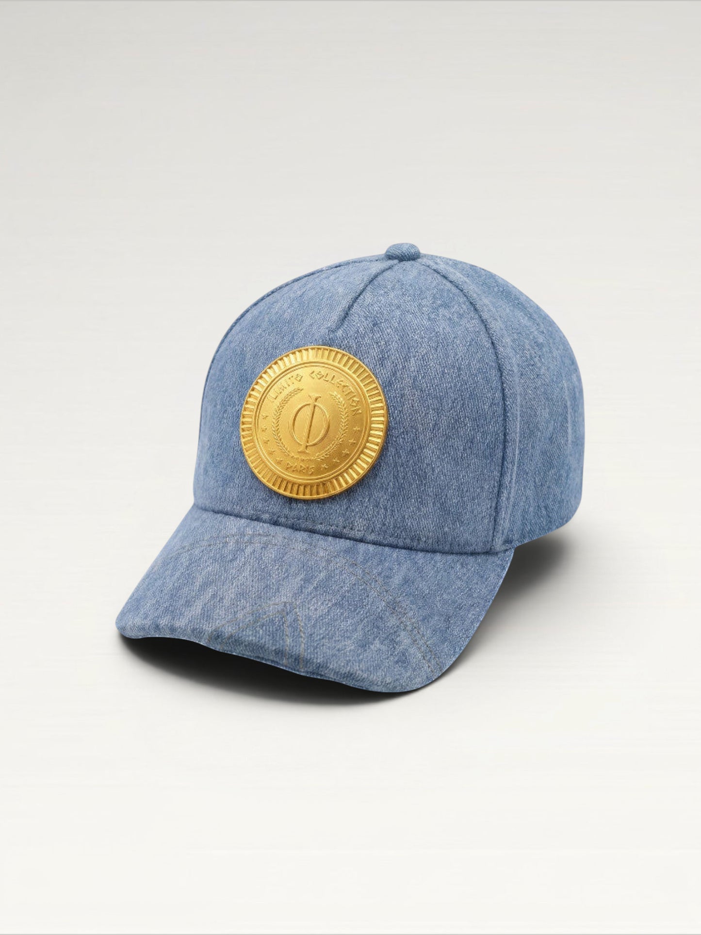 ILIMITO light blue denim baseball cap with curved brim and gold medallion emblem on the front. Unisex fit.