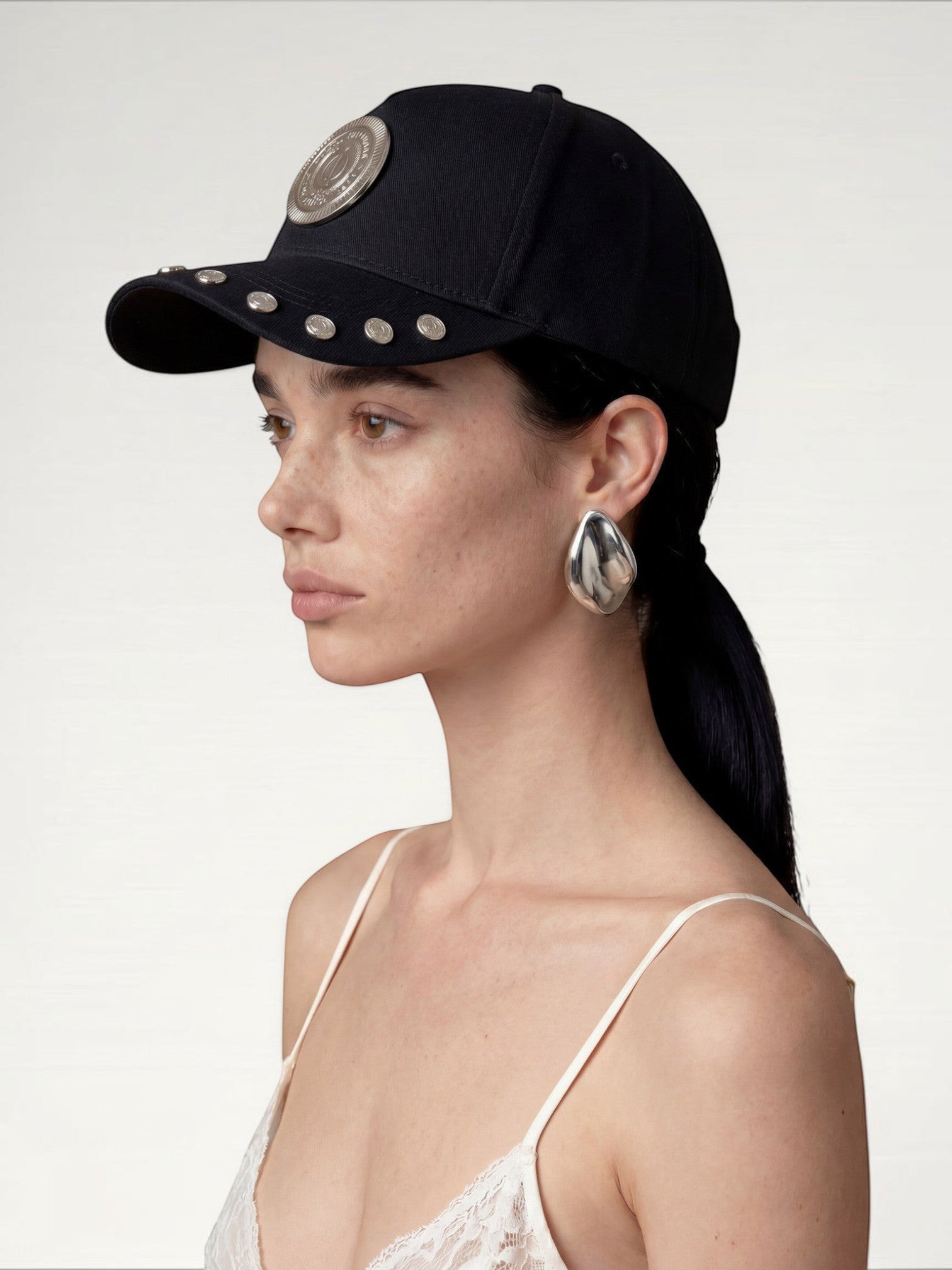 ILIMITO black cotton blend cap with silver medallion detail and metallic accents on the visor. Unisex, adjustable.