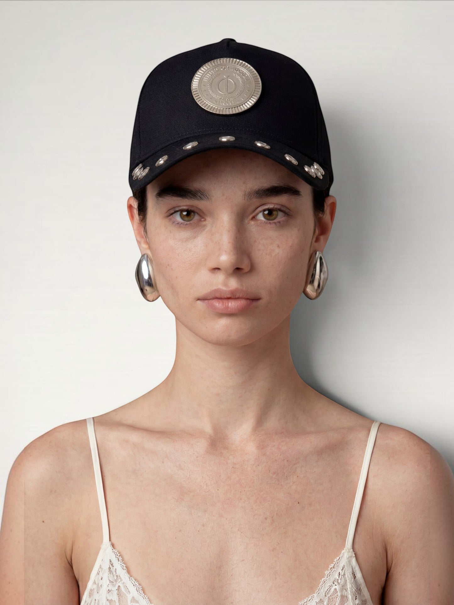 ILIMITO black cotton blend cap with silver medallion detail and silver medal accents on the visor. Unisex fit.