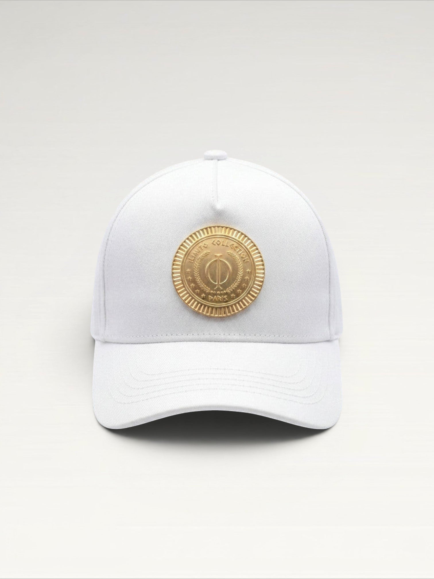 ILIMITO white cotton blend baseball cap with curved brim and gold medallion emblem on the front. Unisex fit.