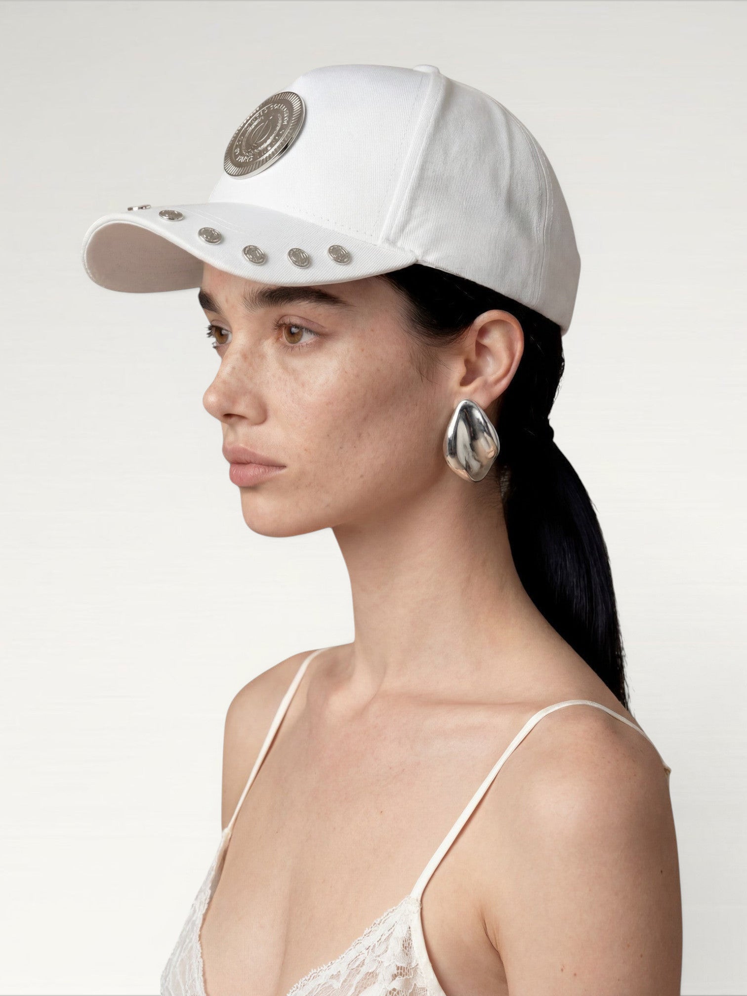 ILIMITO white cotton blend cap with silver medallion detail and accents on the visor. Unisex, adjustable fit.